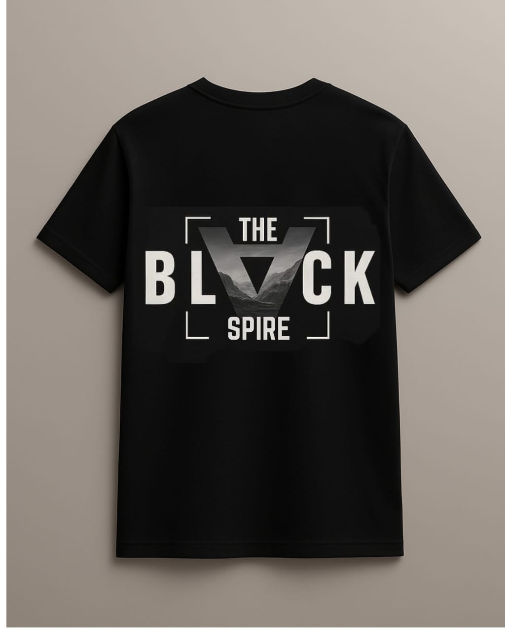 Back view of a black T-shirt displaying 'THE BLACK SPIRE' graphic against a monochrome mountain landscape, from My Store. Perfect for those who embrace modern streetwear.