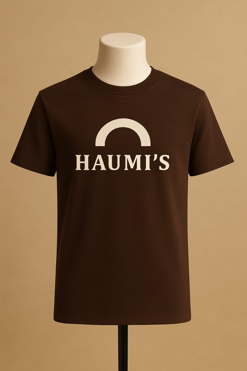 HAUMI’S Legacy Tee – Sandmark Edition in deep brown showcased on a mannequin with a light background, highlighting the elegant, minimalist arch logo.
