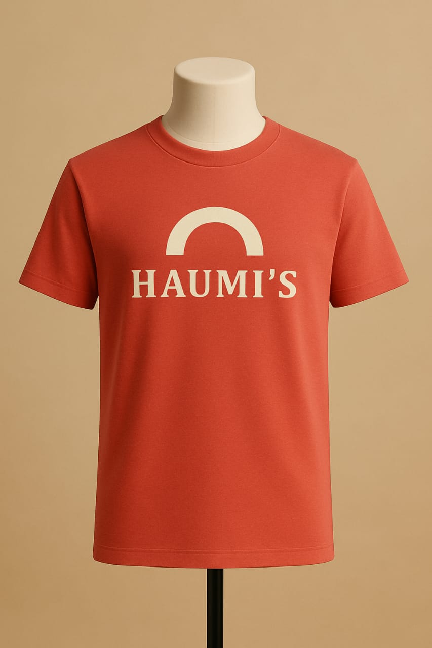 HAUMI’S Legacy Tee – Sandmark Edition in a coral color displayed on a mannequin with a neutral background, showcasing the minimalist arch logo design.