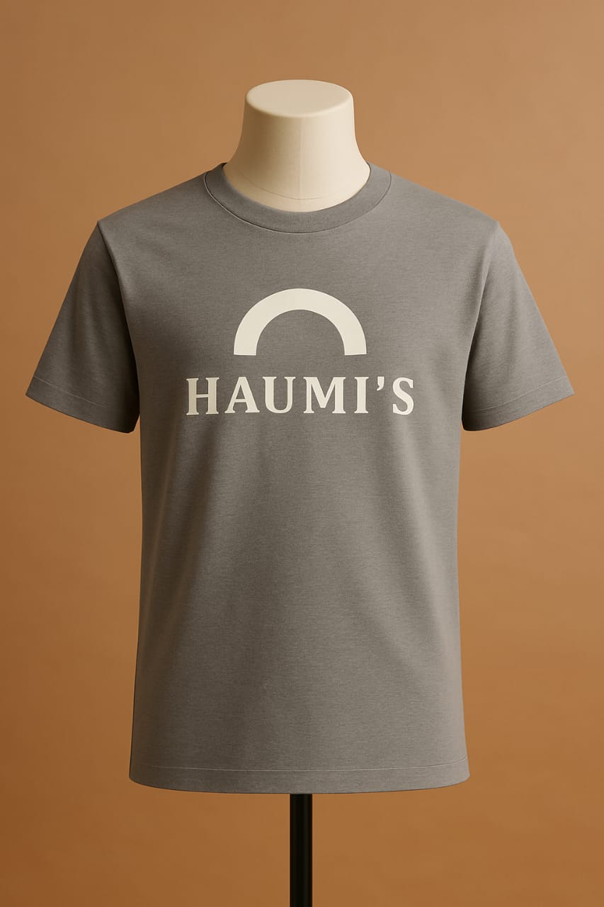 HAUMI’S Legacy Tee – Sandmark Edition in gray showcased on a mannequin with a light brown background, featuring a clean arch logo for a minimalist look.